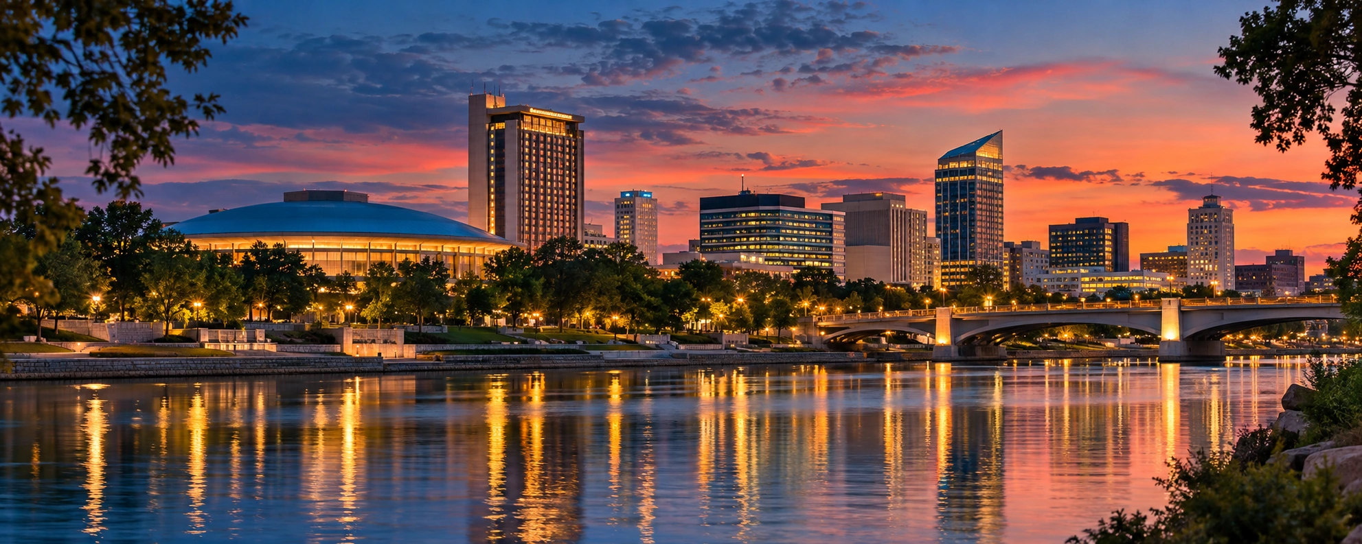 Downtown Wichita-inspired riverfront artwork at sunset, with the skyline and warm lights reflected in the Arkansas River